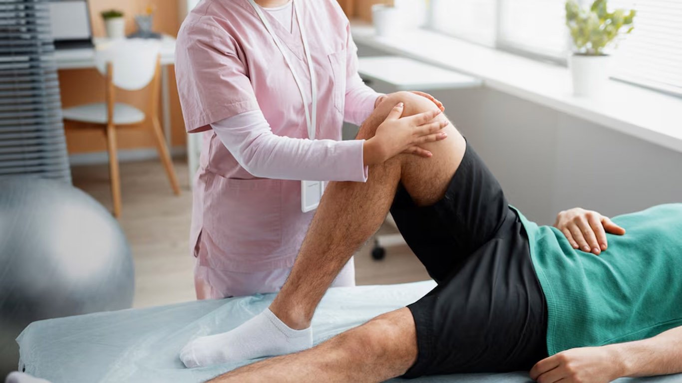 Physiotherapist assessing a patient's knee.