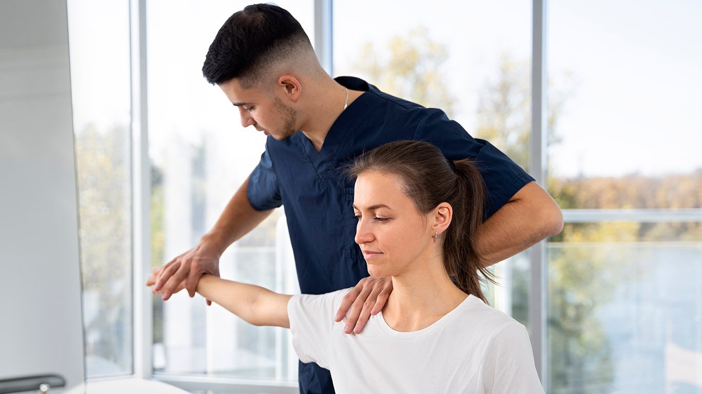 Physiotherapist assessing a patient's shoulder.